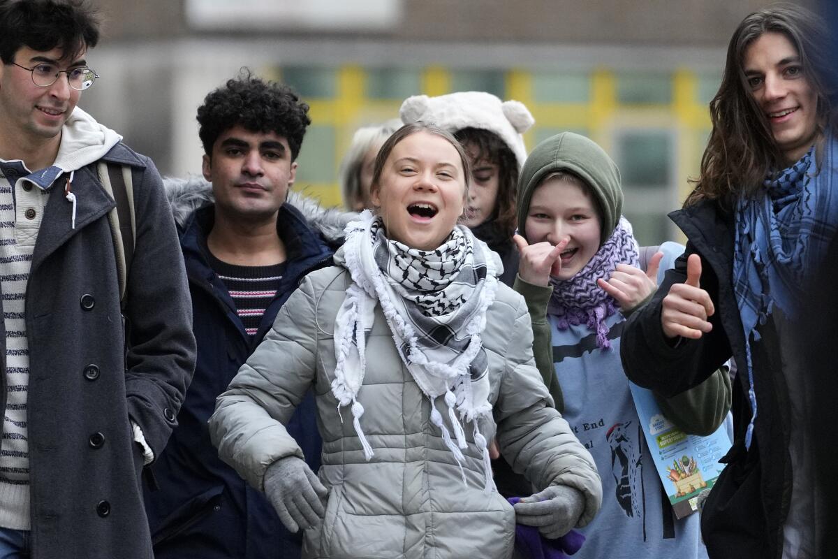 Environmental activist Greta Thunberg, centre, arrives with other protesters at Westminster Magistrates Court in London, Friday, Feb. 2, 2024. A judge has acquitted climate activist Greta Thunberg of a charge that she had refused to leave a protest that blocked the entrance to a major oil and gas industry conference in London last year. Thunberg was acquitted along with four other defendants. (AP Photo/Kirsty Wigglesworth)