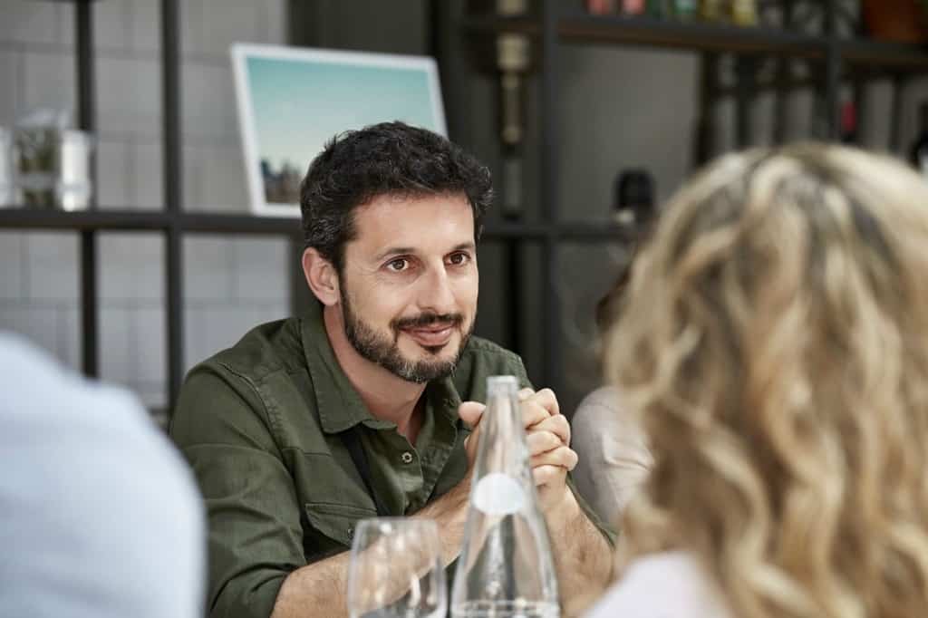 رجل جالس على الطاولة مع آخرين